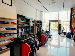 Interior de una tienda de ropa con estanterías y perchas